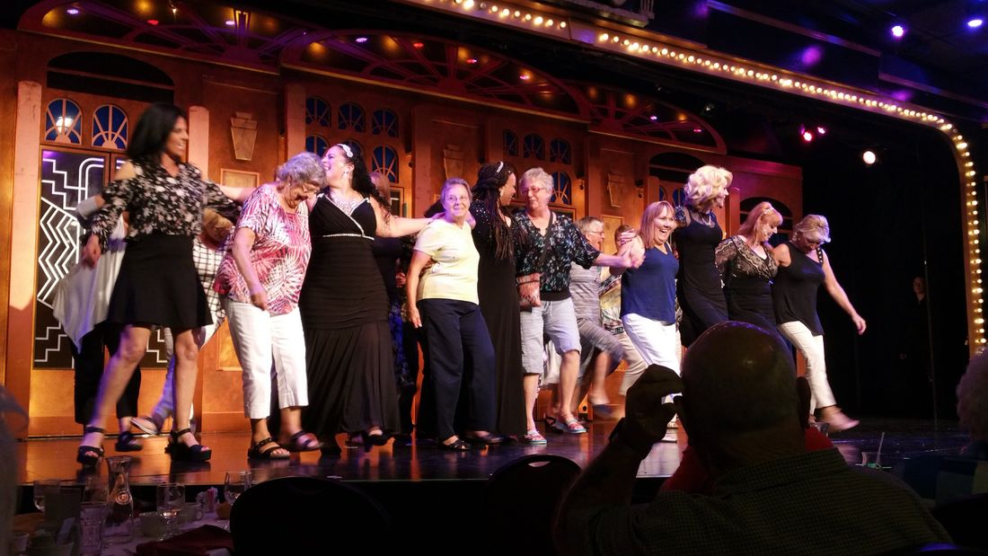 A group from Forest Glenn enjoys dancing onstage with actors at the Show Palace theater dinner show.